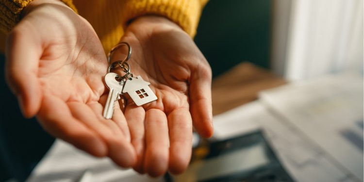 Main avec clé maison à l'intérieur